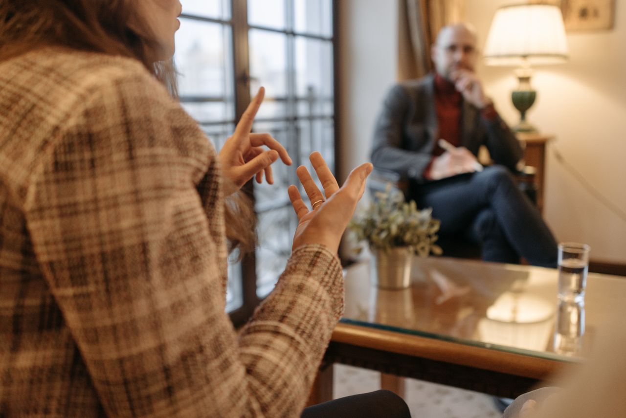 A man and woman engaged in a business conversation at an office setting.